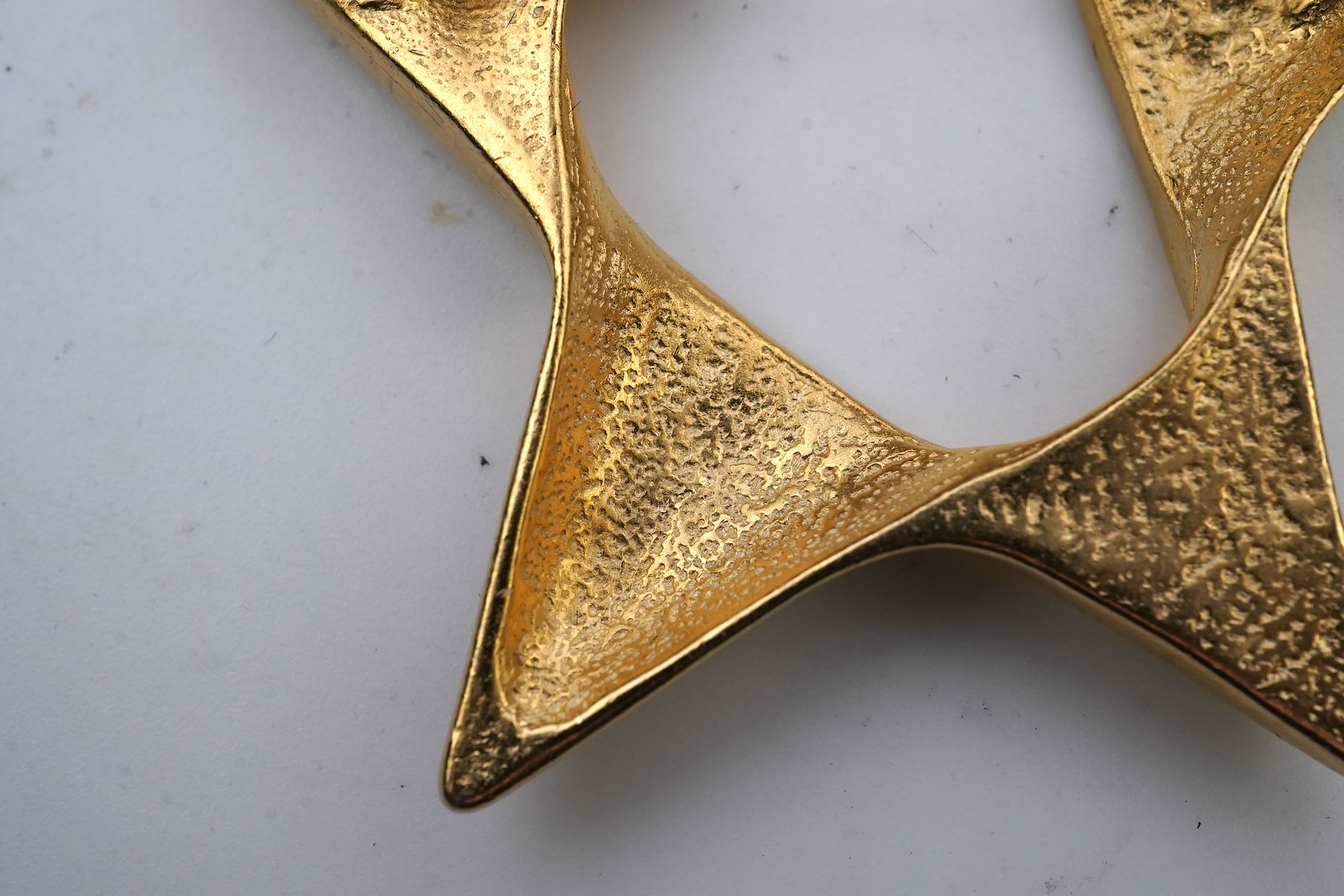 A tarnished gold star brooch in box